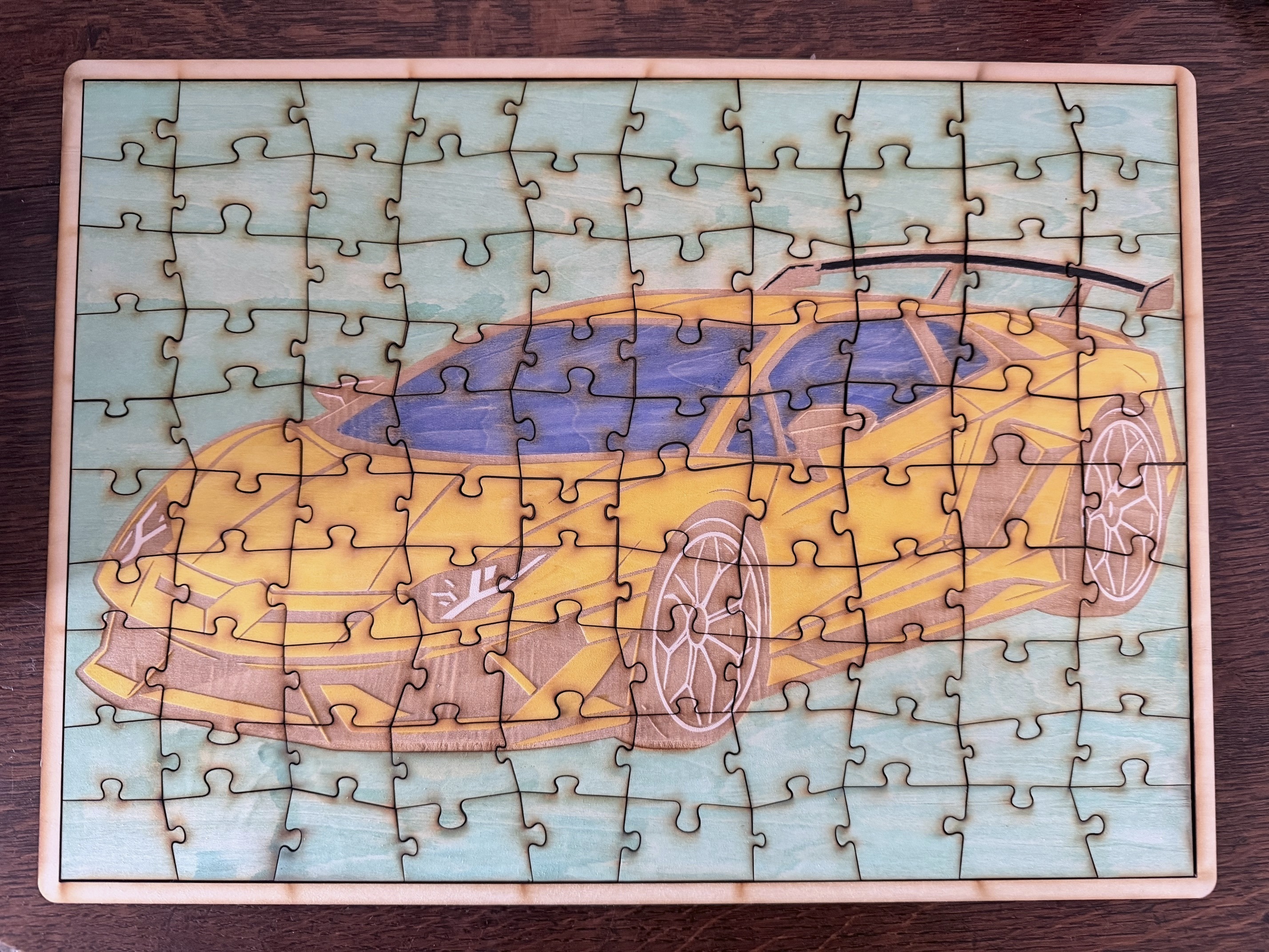 Référence CS 14c — puzzle en bois terminé représentant la Lamborghini jaune choisie et coloriée par l’enfant pendant l’atelier